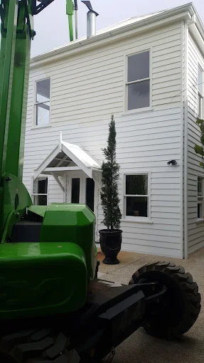 White-painted exterior weatherboards and window trim with access equipment