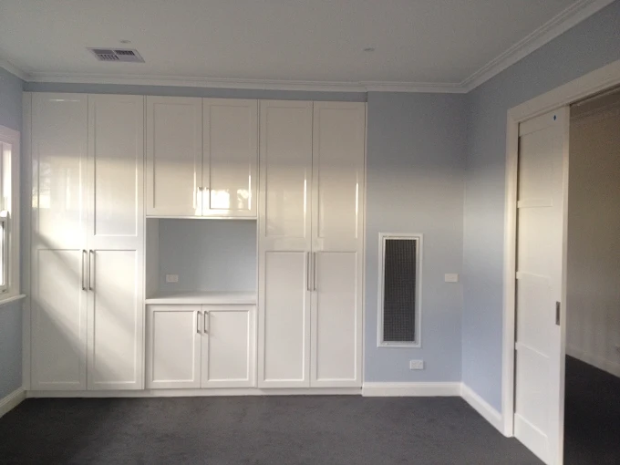 Pale blue interior walls with white built-in cabinetry and trim