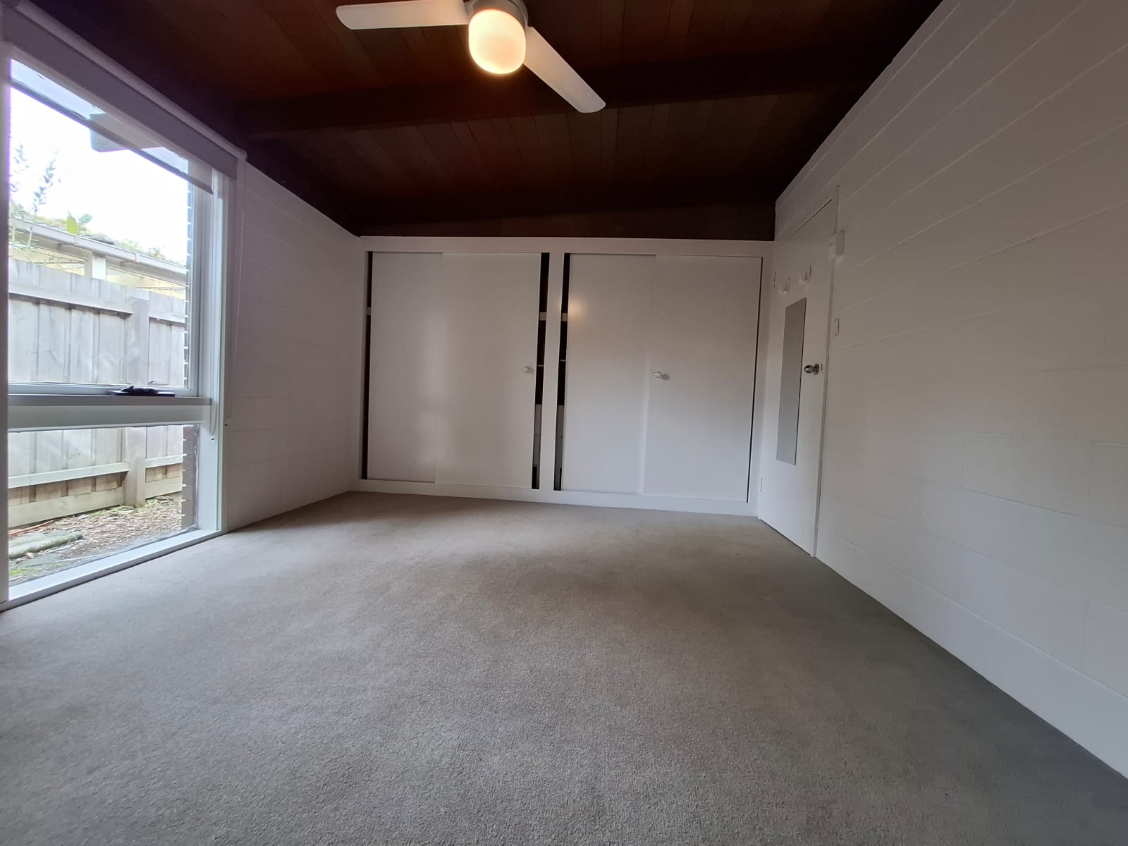 White painted bedroom masonry walls, wardrobe doors and window frame