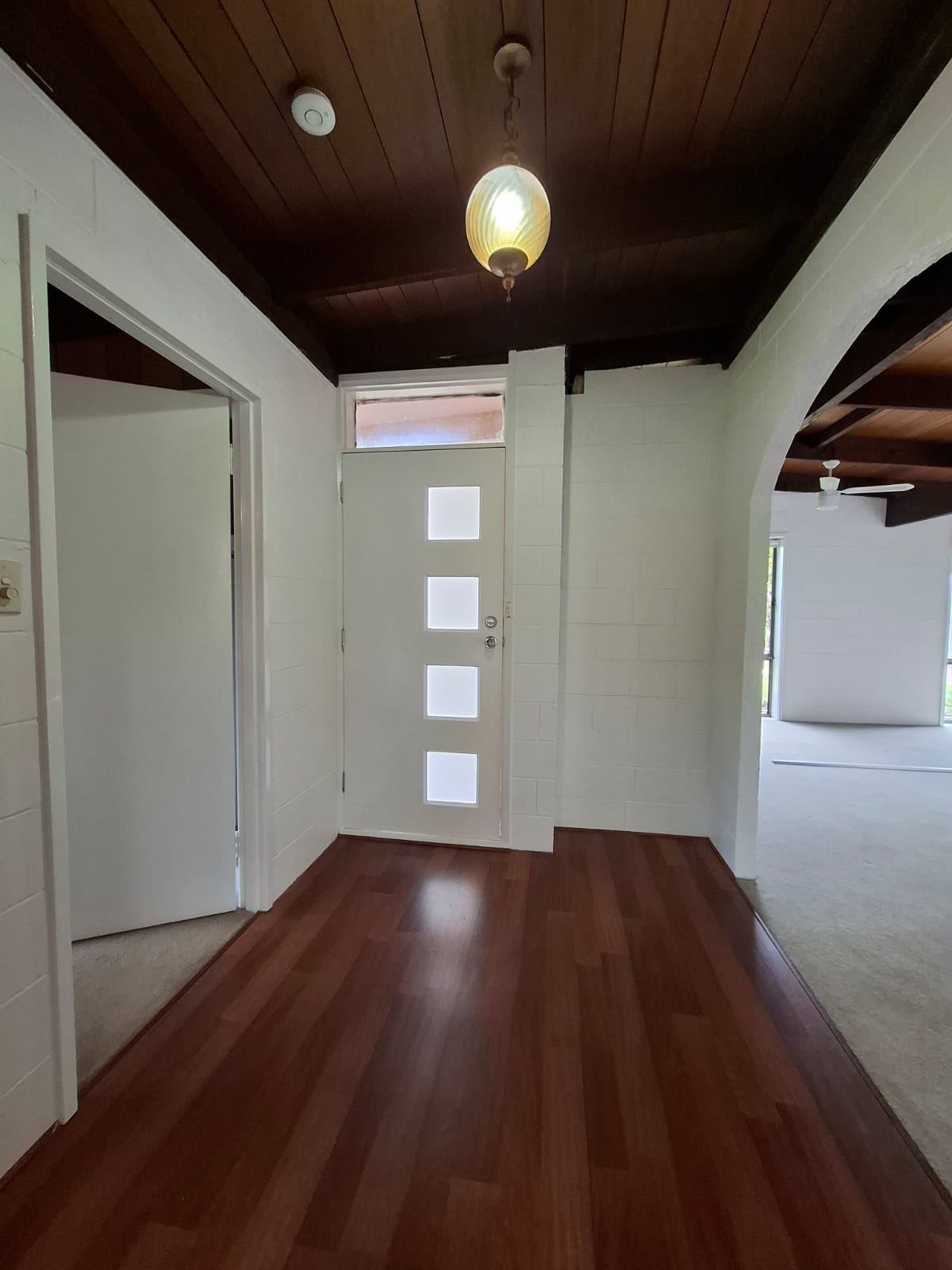 White painted masonry walls, entrance door and internal door frames in a hallway