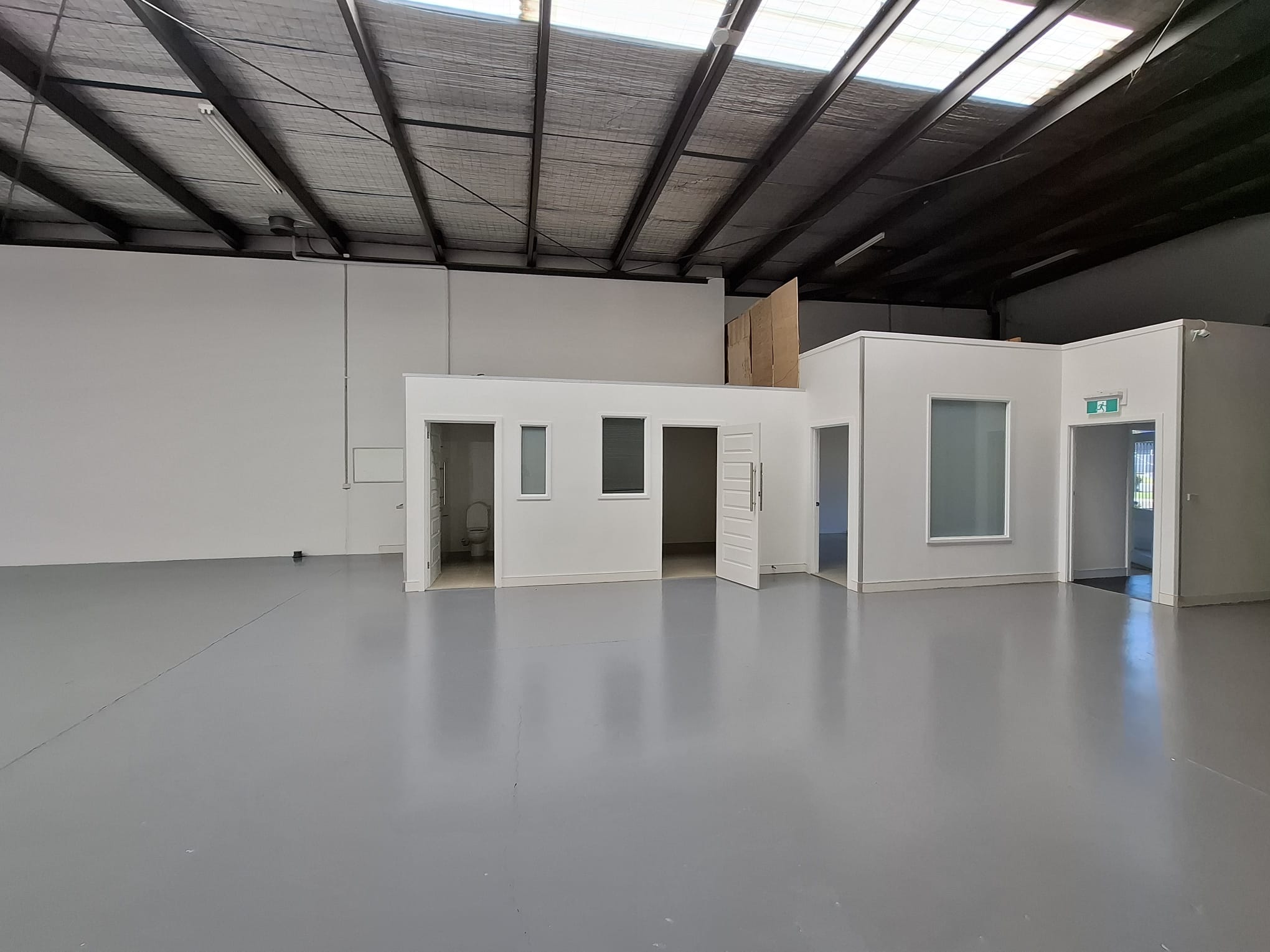 White warehouse walls and office partitions with white doors and window surrounds.