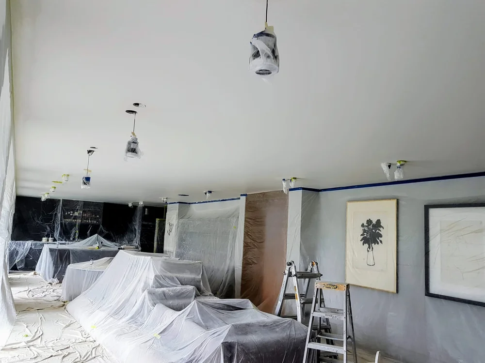 Room prepared for interior painting, with furniture covered